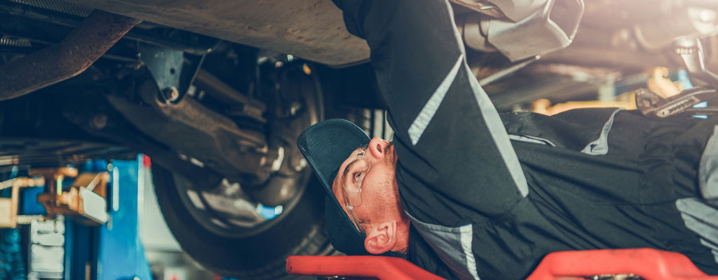 Mechanic working on car exhausts