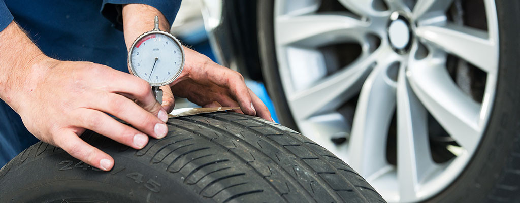 Mechanic checking car tyres